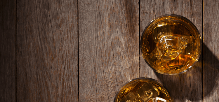 Whiskygläser mit Eiswürfeln auf Holzuntergrund