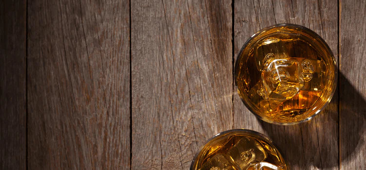 Whiskygläser mit Eiswürfeln auf Holzuntergrund