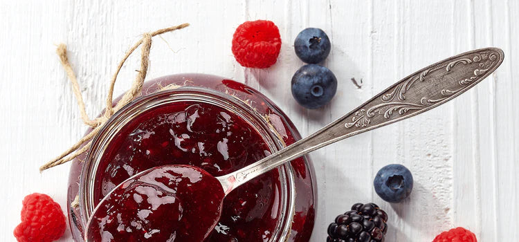 Glas mit roter Marmelade und frischen Beeren